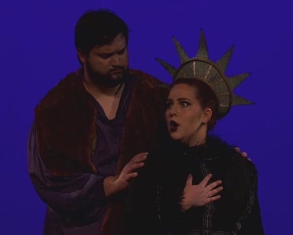 Crown wearing soprano, yearning baritone touches shoulder